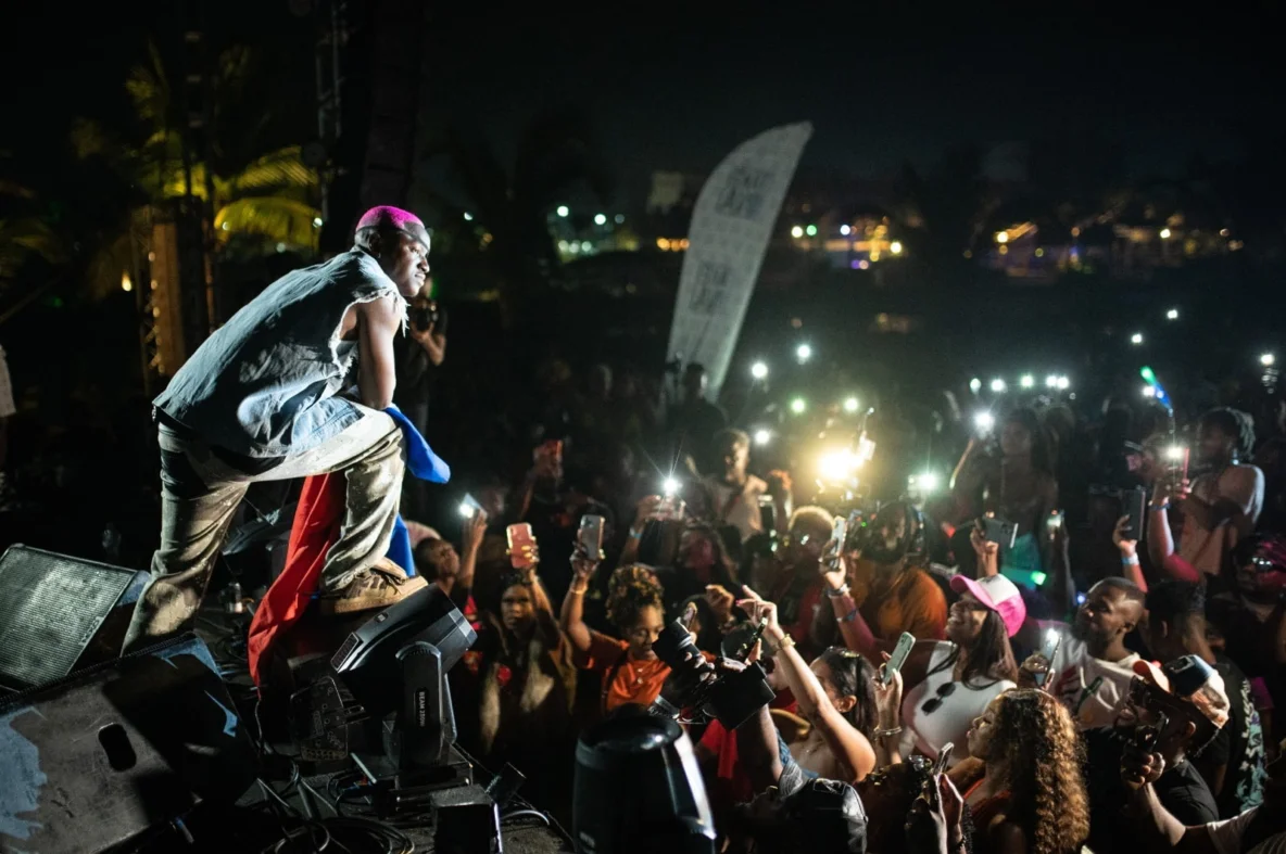 El artista Ruger se presenta en el escenario del festival en Punta Cana frente a una multitud con teléfonos iluminados