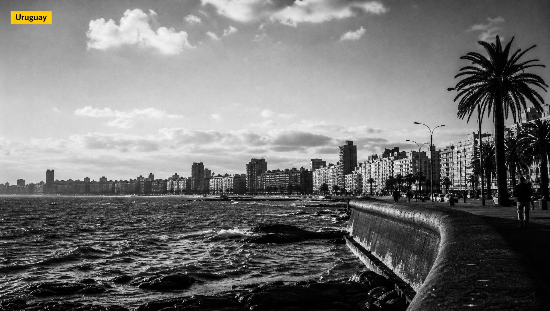 Portada editorial blanco y negro de la rambla de Montevideo con tag amarillo "Uruguay" — cuánto cuesta el influencer marketing en Uruguay